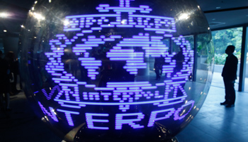 An Interpol logo is projected onto a spherical glass ball during the handing over ceremony (Reuters/Edgar Su)