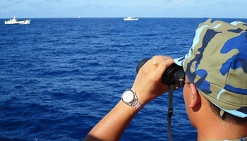 The Vietnamese coastguard look at Chinese vessels in the South China Sea (REUTERS/Martin Petty)