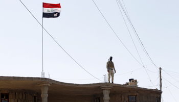 A Sunni fighter who has joined Shi'ite militia groups known collectively as Hashid Shaabi stands guard on a building in al-Alam (Reuters/Ahmed Saad)