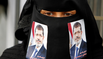 A pro-democracy demonstrator with a photo of Morsi on her veil in Sanaa, Yemen (Reuters/Mohamed al-Sayaghi)