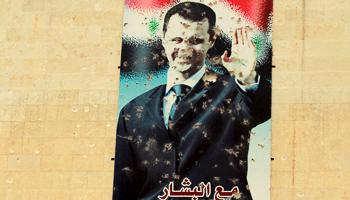 A damaged picture of Assad on a wall in Idlib city (REUTERS/Ammar Abdallah)