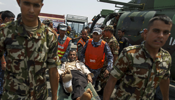 Nepal military personnel carry a survivor in Pokkara airport, Nepal (Reuters/Athit Perawongmetha)