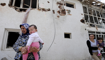 A woman walks through her destroyed house in Kumanovo (Reuters/Ognen Teofilovski)