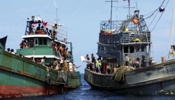 Fishermen give supplies to migrants off the coast of Thailand (Reuters/Stringer)