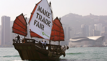 A Chinese junk carrying an Oxfam banner sails past the Hong Kong Convention and Exhibition Centre (Reuters/Bobby Yip)