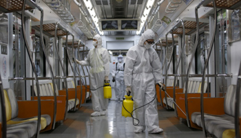Workers disinfect a subway train at a Seoul Metro's railway vehicle base in Goyang, South Korea (Reuters/Kim Hong)