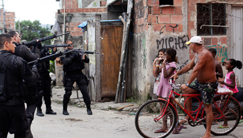 Policemen take position during an operation in the Mare slums complex in Rio de Janeiro, Brazil (Reuters/Ricardo Moraes)