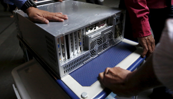 Malaysian plainclothes police remove a hard drive and a box labelled laptops from 1MDB in Kuala Lumpur (Reuters/Olivia Harris)