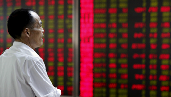 An investor watches stock information at a brokerage office in Beijing, China (Reuters/Kim Kyung)