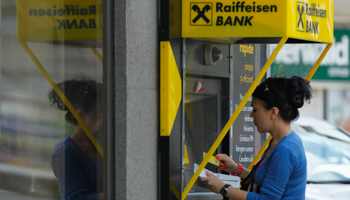 A woman uses the ATM at a branch of Raiffeisen Bank in Bucharest (Reuters/Bogdan Cristel)