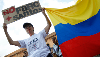 A woman holds up a sign that reads "No more FARC Santos" during a demonstration (Reuters/Jaime Saldarriaga)