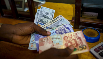A man trades U.S. dollars for Ghanaian cedis at a currency exchange office in Accra, Ghana (Reuters/Francis Kokoroko)
