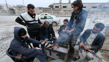 Rebel fighters and civilians warm themselves in Aleppo (Reuters/Abdalrhman Ismail)