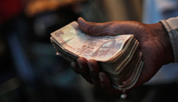 A man holds a bundle of rupees, Delhi (Reuters/Adnan Abidi)