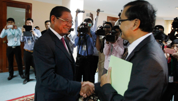 Sar Kheng shakes hands with Sam Rainsy (Reuters/Samrang Pring)