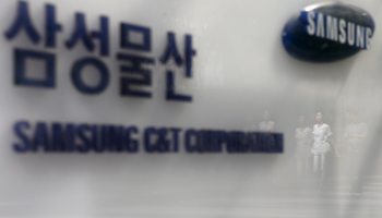 Employees are reflected on a logo of Samsung C&T Corp at the company's headquarters in Seoul, South Korea (Reuters/Kim Hong)