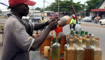 A trader bottles smuggled fuel on a street of Benin's capital Cotonou (Reuters/Noel Kokou Tadegnon)