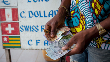 A man trades U.S. dollars for Ghanaian cedis at a currency exchange office in Accra (Reuters/Francis Kokoroko)