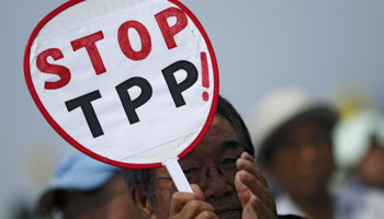 A Japanese farmer holding placard against Trans-Pacific Partnership participates in a rally (Reuters/Yuya Shino)