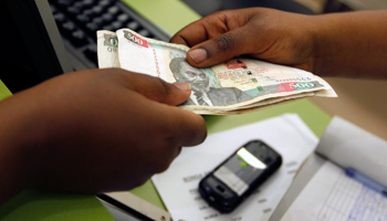 A customer conducts a mobile money transfer, inside the Safaricom mobile phone care centre in Nairobi (Reuters/Thomas Mukoya)