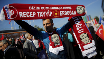 A man holds scarves bearing the names and images of Turkish Prime Minister Ahmet Davutoglu and President Tayyip Erdogan as supporters of the AK Party (Reuters/Murad Sezer)