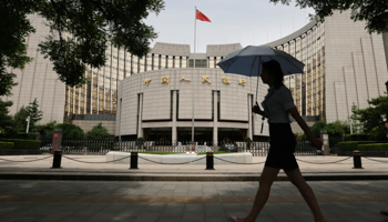 A woman walks past the headquarters of the People's Bank of China, the central bank, in Beijing (Reuters/Jason Lee)