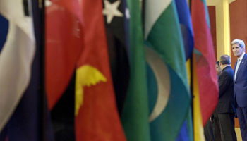 Flags at the 22nd Association of Southeast Asian Nations Regional Forum session in Kuala Lumpur, with John Kerry and other foreign ministers in the background (Reuters/Brendan Smialowski/Pool)