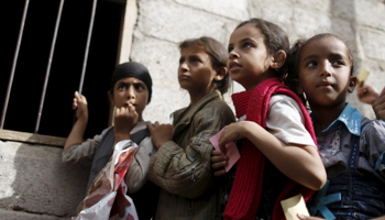 Girls wait for food rations outside a charity food assistance center in Sanaa (Reuters/Khaled Abdullah)