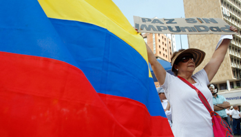 A woman holds up a sign reading, "Peace without impunity" in a demonstration against the Revolutionary Armed Forces of Colombia (Reuters/Jaime Saldarriaga)