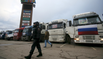 A police officer walks past a line of trucks, whose drivers are taking part in a protest against a new fee, Moscow region (Reuters/Maxim Shemetov)