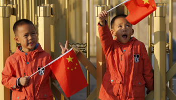 Twin boys hold China's national flags on the Tiananmen Gate in Beijing (Reuters/Kim Kyung)