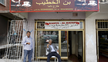 A Syrian man, on the right, sits outside his coffee shop in a neighborhood of Ankara (Reuters/Umit Bektas)