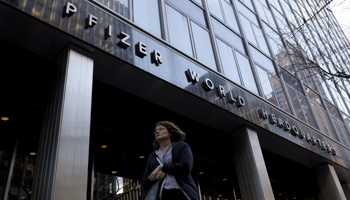 A woman passes by the Pfizer World Headquarters building in the Manhattan borough of New York (Reuters/Brendan McDermid)