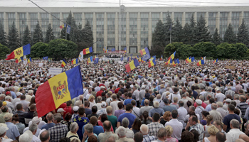 Protesters carry Moldova's national flags during an anti-government rally (Reuters/Valery Korchmar)