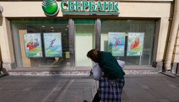 An elderly woman passes by office's of Sberbank in St. Petersburg (Reuters/Alexander Demianchuk)