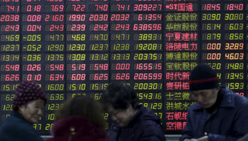 Investors stand in front of an electronic board showing stock information on the first trading day after the Lunar New Year holiday in Shanghai, China (Reuters/Aly Song)