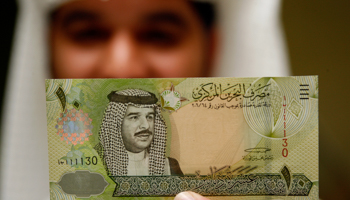Central Bank of Bahrain official holds a 10 dinar bank note (Reuters/Hamad I Mohammed)
