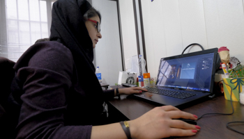 An employee works on her laptop in Tehran, Iran (Reuters/Raheb Homavandi)