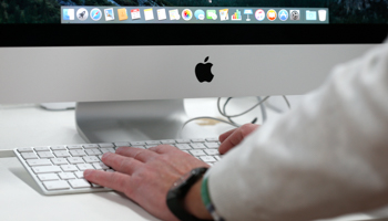 A customer tests an Apple computer in a shop in Munich, Germany (Reuters/Michaela Rehle)