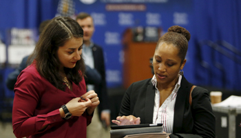 A job applicant has her resume looked at during a US Chamber of Commerce Foundation job fair in Washington (Reuters/Gary Cameron)