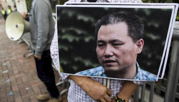 A protester holds a portrait of human rights lawyer Pu Zhiqiang (Reuters/Tyrone Siu)