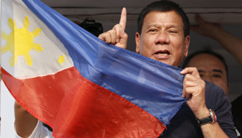 Rodrigo Duterte holds the national flag in Malabon, Philippines (Reuters/Erik De Castro)