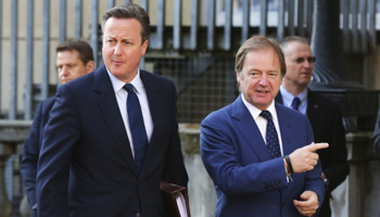 UK Prime Minister David Cameron is met by Foreign Office minister Hugo Swire as he arrives at a summit on corruption in London (Reuters/Paul Hackett)