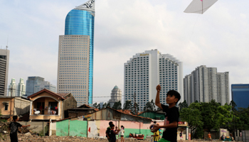 Children fly their kites near demolished houses in Jakarta (Reuters/Beawiharta)