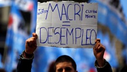 A man holds up a sign that reads "Argentine President Mauricio Macri equals unemployment" during a demonstration, Buenos Aires (Reuters/Marcos Brindicci)