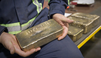 A worker holds a polished gold alloy bar in a gold mine workshop, Bishkek (Reuters/Shamil Zhumatov)