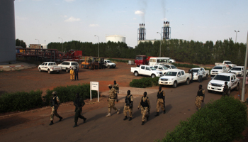South Sudanse soldiers walk past an oil field facility (Reuters/Andreea Campeanu)