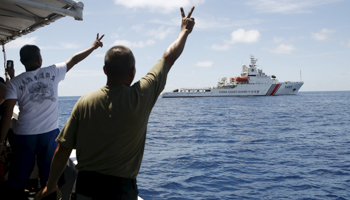 Filipino soldiers gesture at a Chinese Coast Guard vessel on the disputed Second Thomas Shoal (Reuters/Erik De Castro)