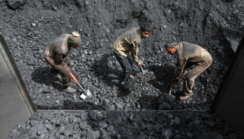 Labourers load coal on trucks at Bari Brahamina, India (Reuters/Mukesh Gupta)