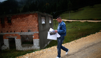 A census official walks past houses near Srebrenica destroyed during the 1992-95 war in October 2013 (Reuters/Dado Ruvic)